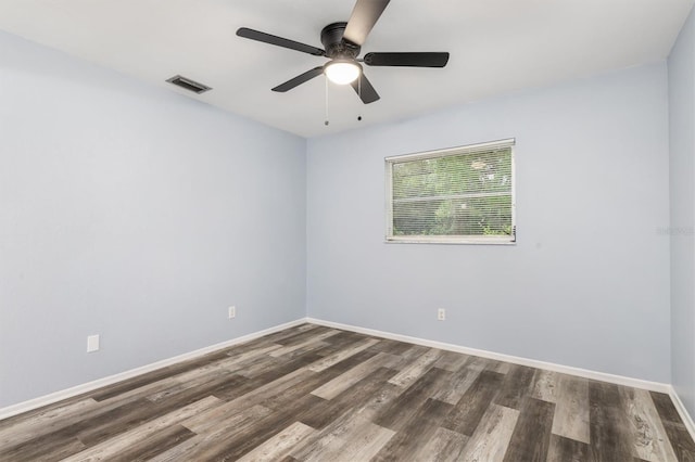 spare room featuring baseboards, wood finished floors, visible vents, and ceiling fan