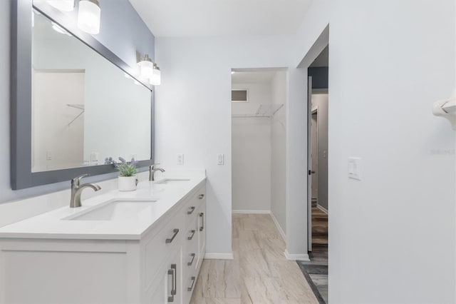 full bathroom with a sink, double vanity, and a spacious closet