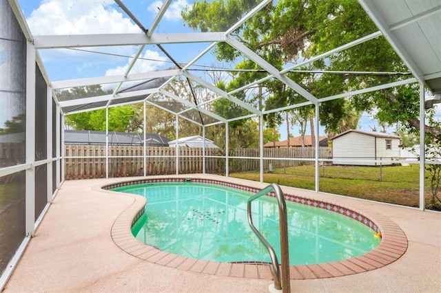 view of swimming pool featuring a yard, a fenced in pool, a fenced backyard, and glass enclosure