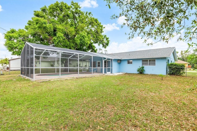 rear view of house with an outdoor pool, a yard, a lanai, and stucco siding