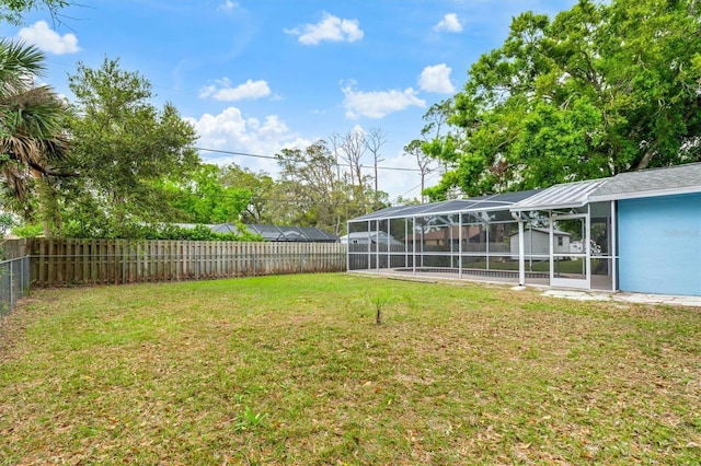 view of yard with a lanai and a fenced backyard