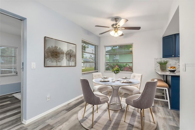 dining room featuring baseboards, light wood-style floors, and ceiling fan