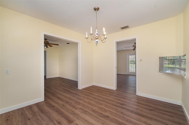 spare room featuring wood finished floors, visible vents, a chandelier, and baseboards