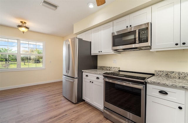 kitchen with visible vents, baseboards, stainless steel appliances, light wood-style floors, and white cabinetry