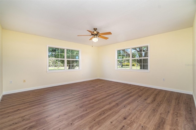 empty room featuring ceiling fan, baseboards, and wood finished floors