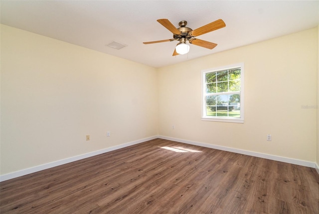 empty room featuring a ceiling fan, wood finished floors, and baseboards