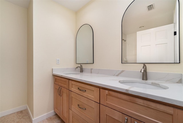 bathroom featuring double vanity, baseboards, visible vents, and a sink