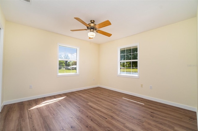 unfurnished room with a ceiling fan, baseboards, and wood finished floors