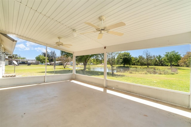 unfurnished sunroom featuring a water view and ceiling fan