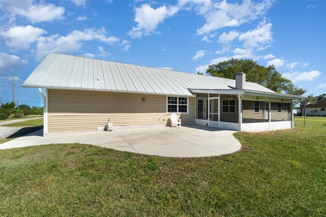 back of property with a patio, a yard, a sunroom, and metal roof