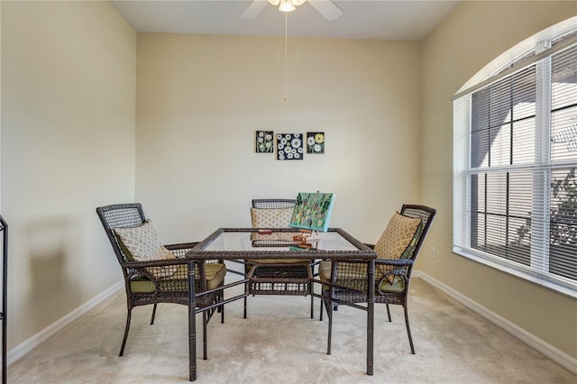 dining space with light colored carpet, baseboards, and ceiling fan