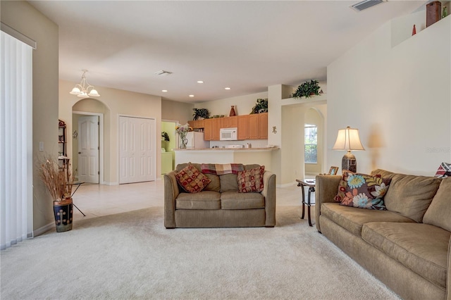 living area featuring recessed lighting, baseboards, light carpet, and arched walkways