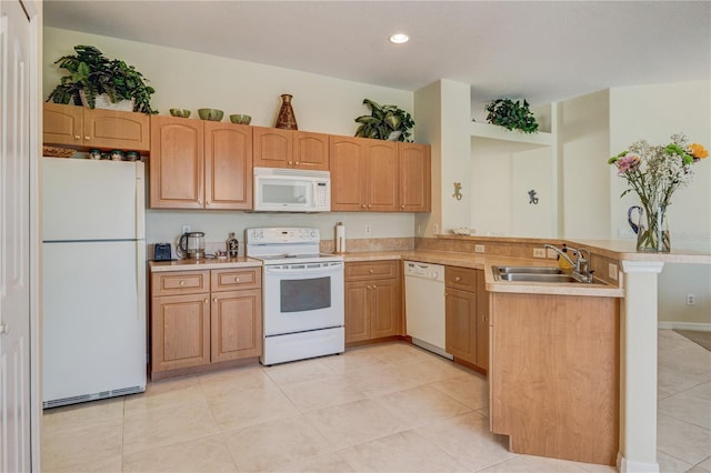 kitchen with white appliances, a peninsula, light countertops, and a sink