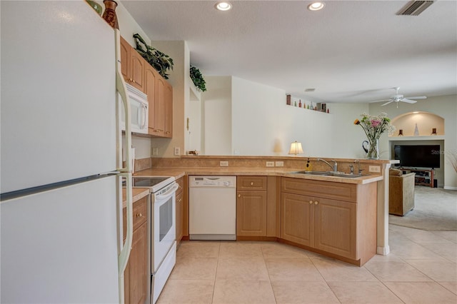 kitchen with visible vents, open floor plan, a peninsula, white appliances, and a sink