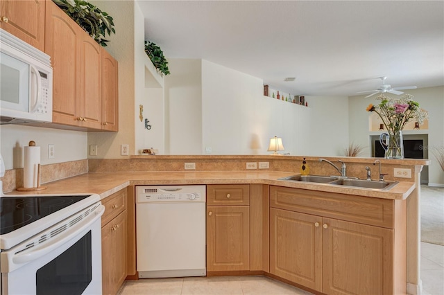 kitchen featuring light countertops, a peninsula, white appliances, a ceiling fan, and a sink