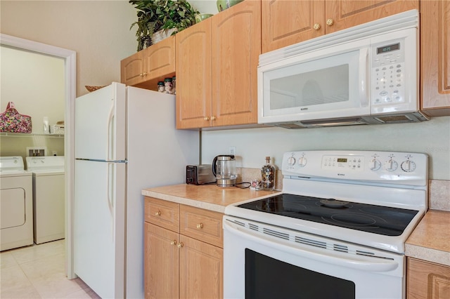 kitchen featuring light brown cabinetry, white appliances, light countertops, light tile patterned floors, and washing machine and clothes dryer