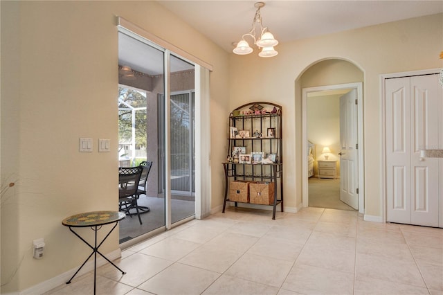 interior space with light tile patterned floors, baseboards, and a chandelier