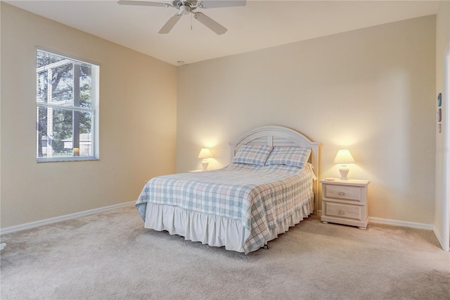 bedroom with light colored carpet, baseboards, and ceiling fan