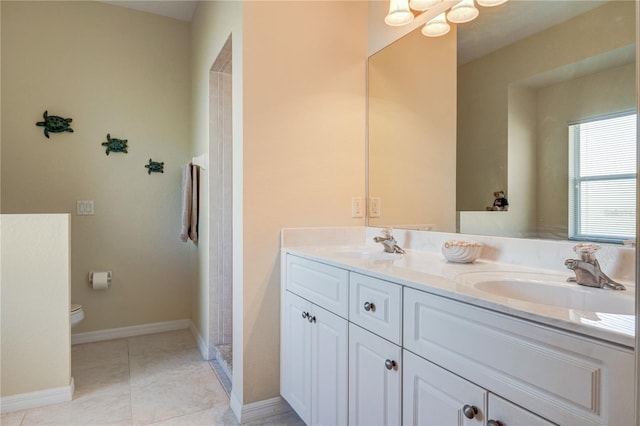 bathroom with tile patterned floors, toilet, double vanity, and a sink