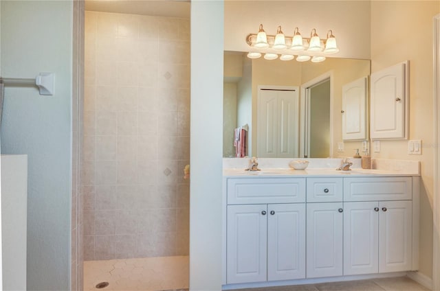 bathroom featuring double vanity, a tile shower, and a sink