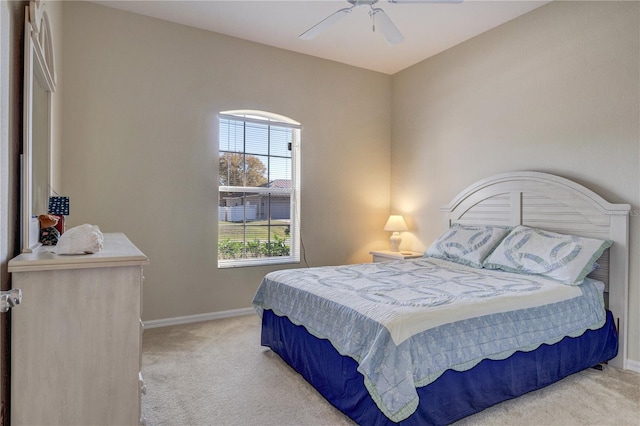 bedroom with baseboards, light carpet, and a ceiling fan