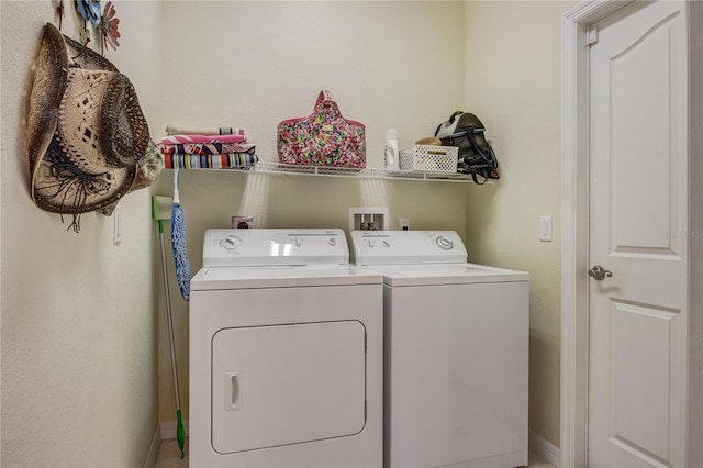 clothes washing area featuring laundry area, washing machine and dryer, and baseboards