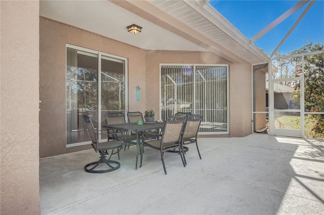 view of patio featuring outdoor dining space and a lanai