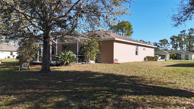 rear view of property with stucco siding and a lawn