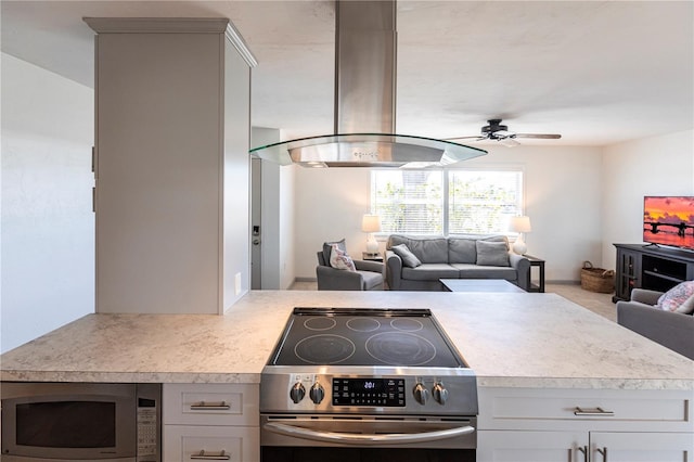 kitchen featuring ceiling fan, light countertops, appliances with stainless steel finishes, open floor plan, and island range hood