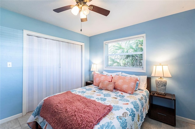 bedroom with tile patterned floors, a closet, baseboards, and ceiling fan