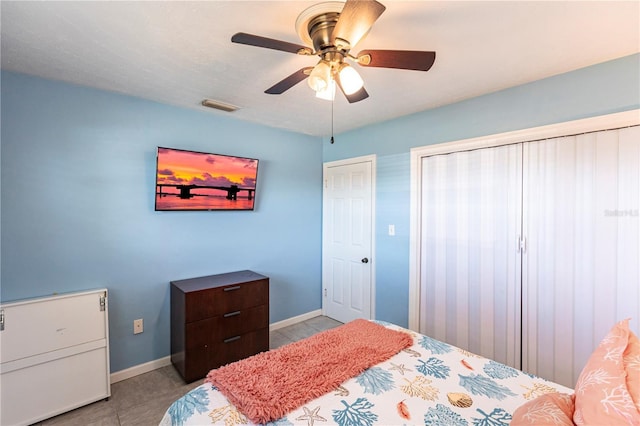 bedroom featuring a ceiling fan, light tile patterned floors, baseboards, and visible vents