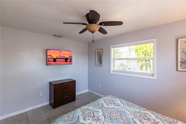 tiled bedroom with baseboards and ceiling fan