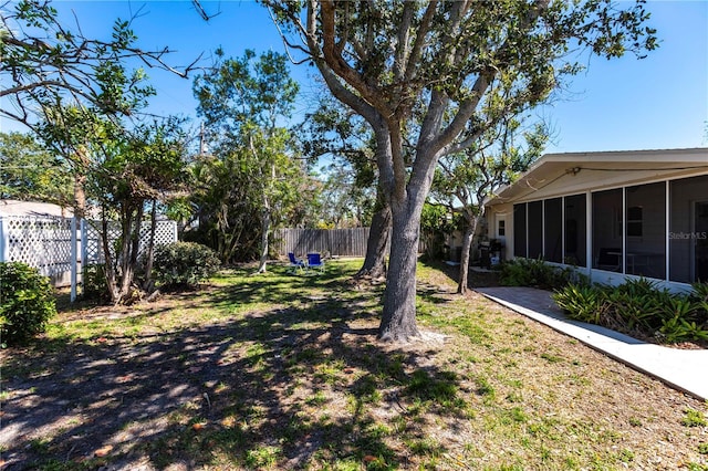 view of yard with a fenced backyard and a sunroom