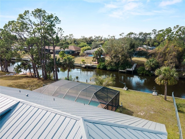 view of dock featuring a water view, a lawn, and a lanai