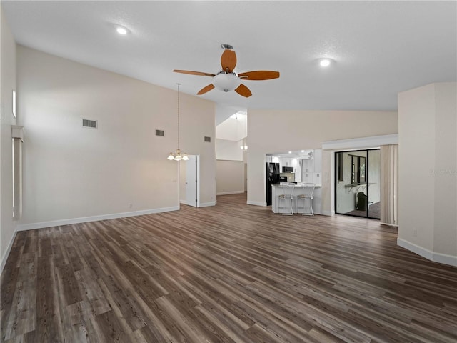 unfurnished living room with dark wood finished floors, visible vents, ceiling fan with notable chandelier, and baseboards