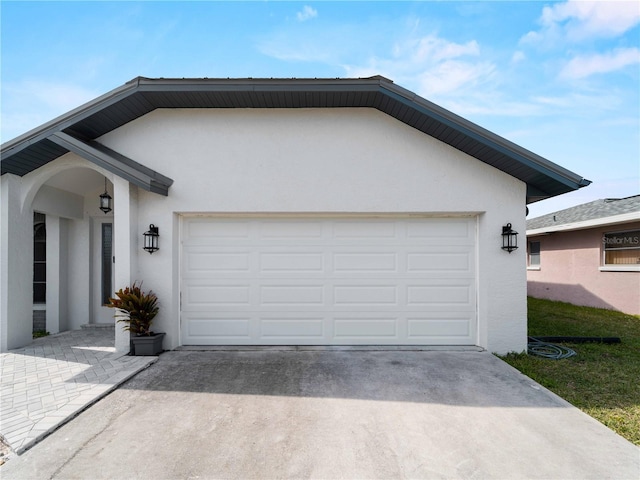 single story home with concrete driveway, an attached garage, and stucco siding