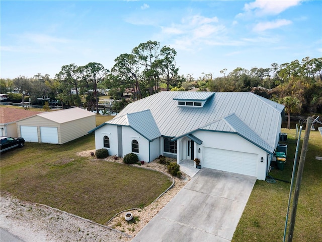 view of front of home featuring a front lawn, stucco siding, metal roof, an attached garage, and a standing seam roof