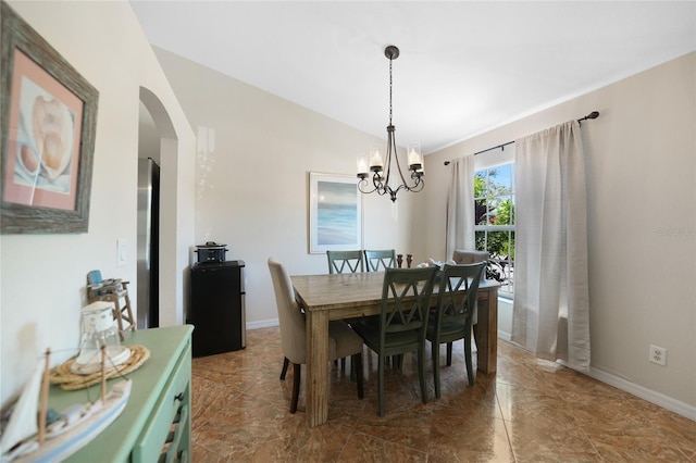 dining area with arched walkways, baseboards, an inviting chandelier, and vaulted ceiling