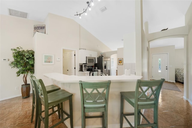 kitchen featuring a breakfast bar, visible vents, and appliances with stainless steel finishes