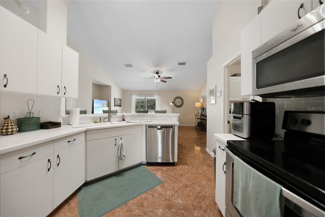 kitchen with tasteful backsplash, appliances with stainless steel finishes, light countertops, and a sink