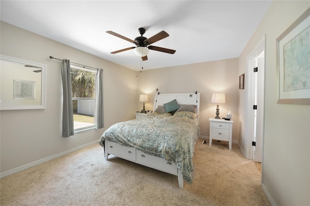 bedroom with light colored carpet, baseboards, and ceiling fan