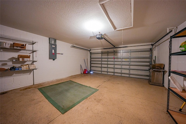 garage with concrete block wall, electric panel, and a garage door opener