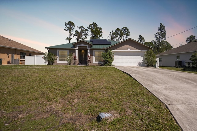 view of front of house with solar panels, a front lawn, fence, concrete driveway, and central AC unit