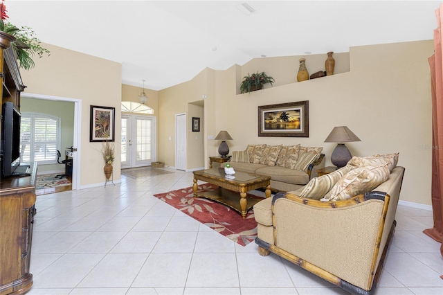 living area with light tile patterned floors, french doors, baseboards, and vaulted ceiling