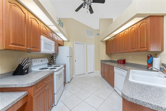 kitchen with white appliances, light tile patterned floors, visible vents, a sink, and brown cabinets