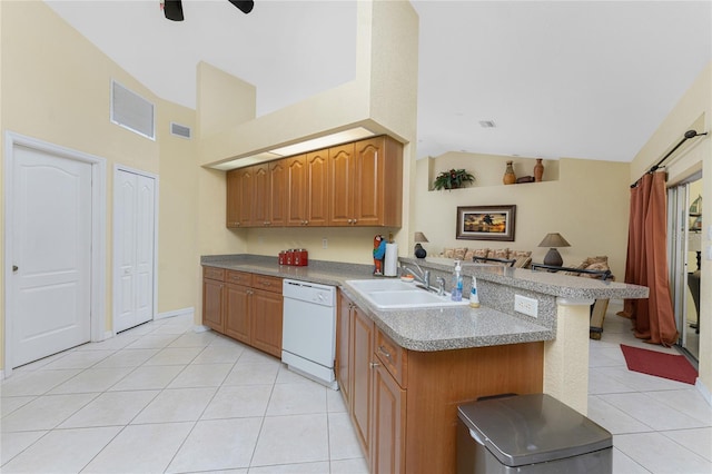 kitchen featuring visible vents, a peninsula, white dishwasher, light tile patterned flooring, and a sink