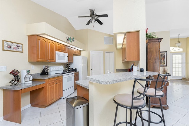 kitchen with white appliances, visible vents, a breakfast bar, a peninsula, and light tile patterned flooring