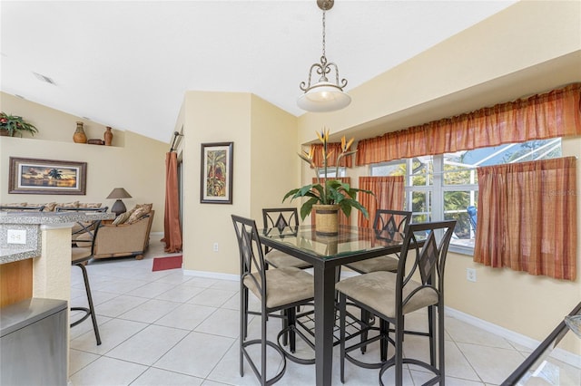 dining room featuring light tile patterned floors, visible vents, baseboards, and vaulted ceiling