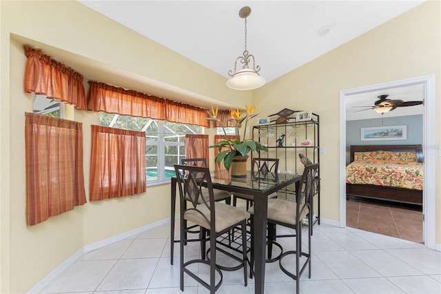 dining space featuring vaulted ceiling, light tile patterned flooring, a ceiling fan, and baseboards