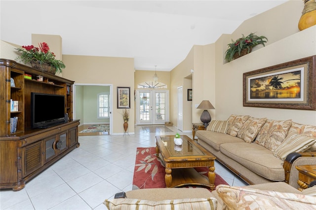 living area featuring vaulted ceiling, light tile patterned flooring, french doors, and baseboards